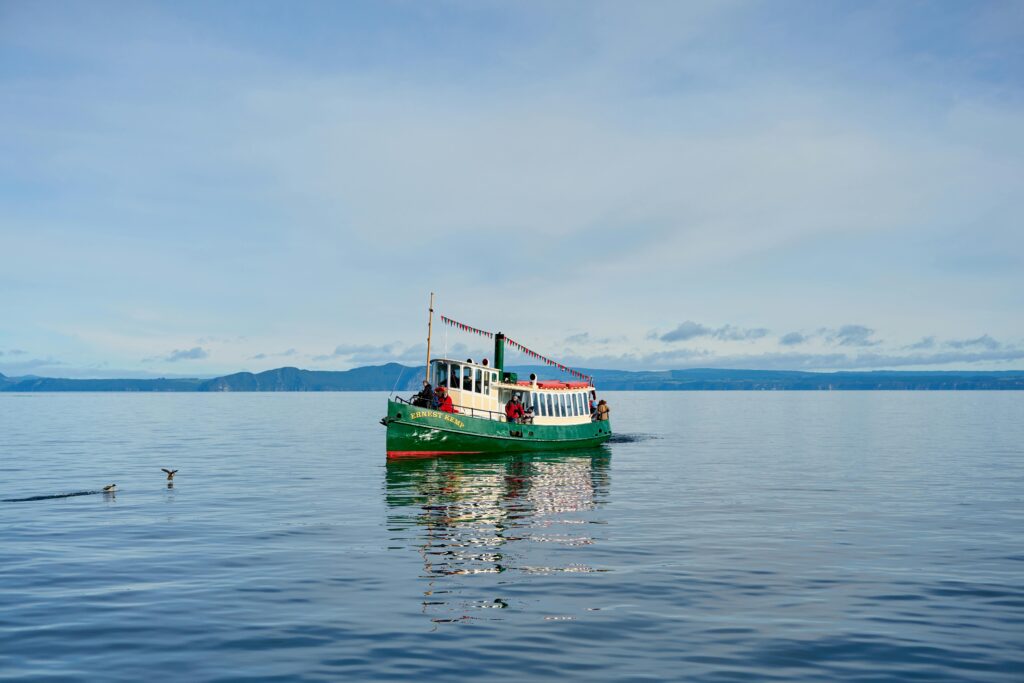 A vibrant boat on the serene waters of Lake Taupō, capturing the tranquil beauty and adventure of New Zealand.