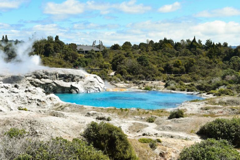 Explore the striking geothermal landscape and azure lake in Rotorua's unique natural setting.