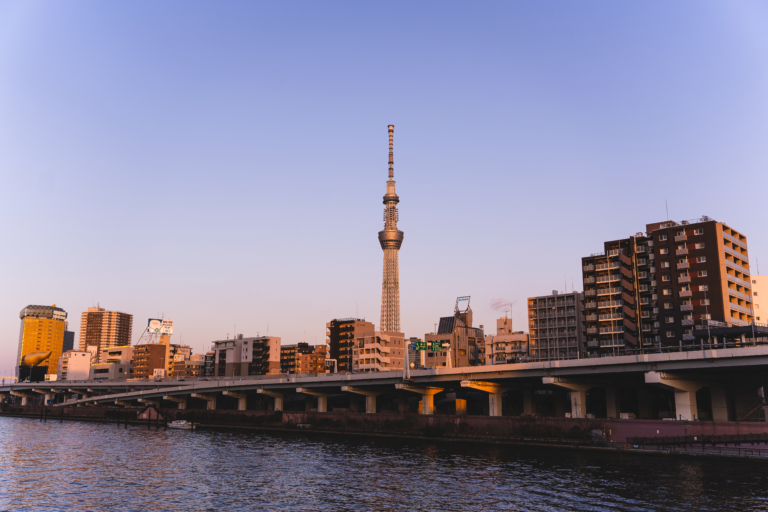 Tokyo Skytree and urban skyline at dusk along the Sumida River in Japan.